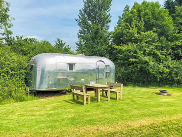 Airstream with table, chairs and fire basket