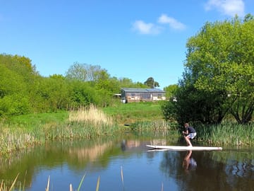 Taking a paddle board out on the wildlife pond, Balebarn Eco Lodge in the background (added by manager 19 Jan 2018)