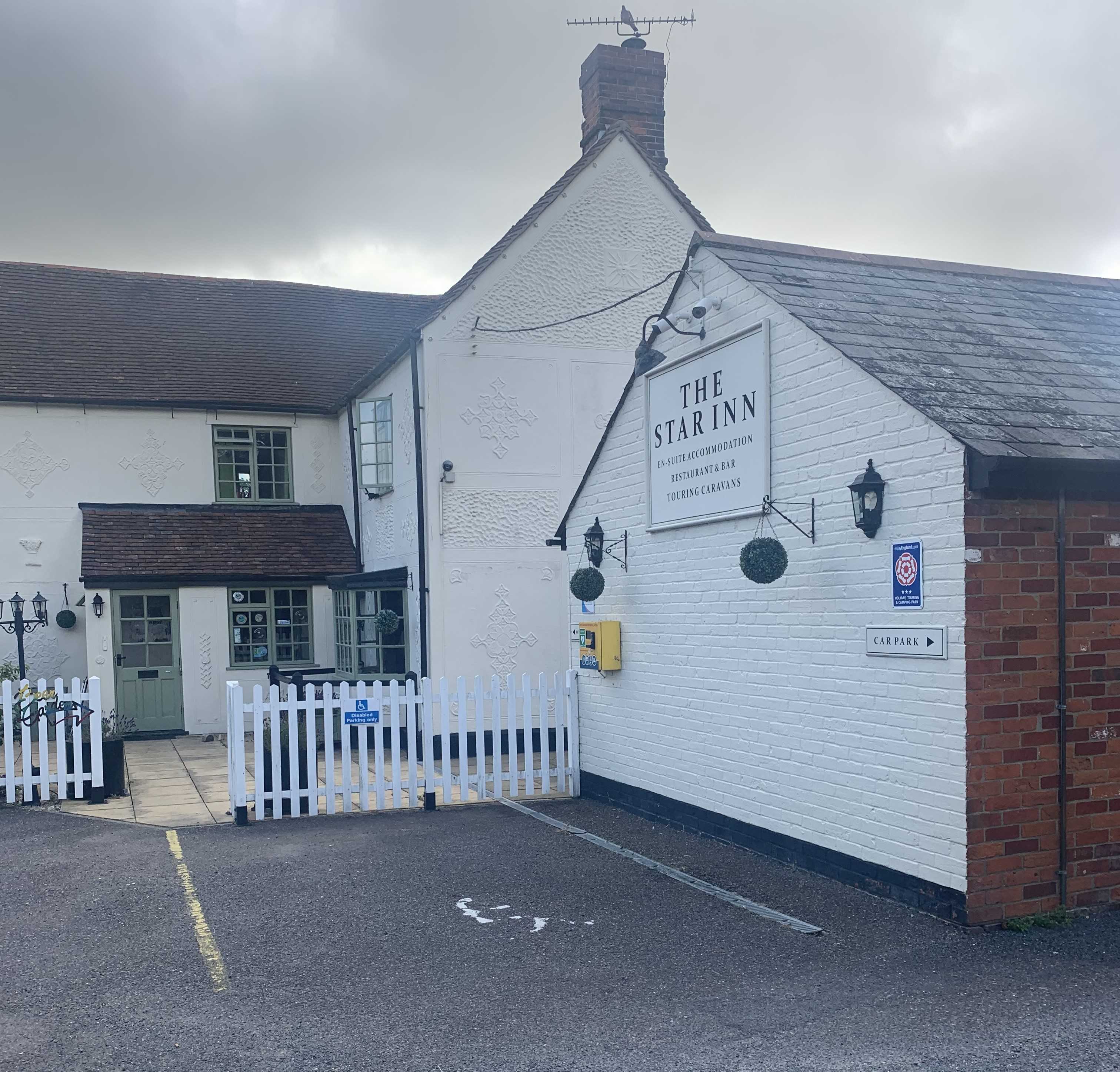 Image shows an accessible car parking space infront of a pub with a level access entrance