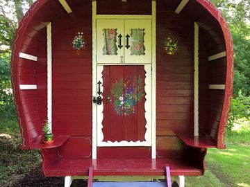Bow top gypsy caravan painted in traditional colours