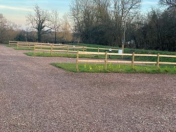 New fencing between pitches with young laurel hedging. the soil bank has been seeded with grass and