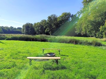 Firepit and pitches surrounded by greenery