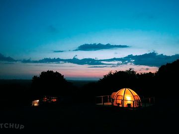Glamping tents lit up after dark