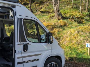 Motor home pitches next to green slope