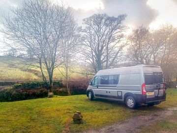 Campervan pitched by the river