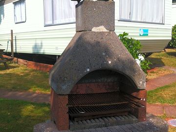 Stone barbecue outside two-bedroom static caravan (added by manager 02 jul 2014)