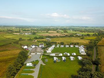 Hardstanding electric pitches left, fully serviced hardstanding pitches backing onto the hedge