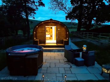 Nigh time view of hot tub and pod