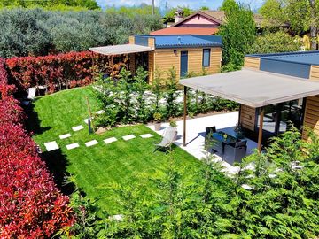 Spazio esterno dell'alloggio: veranda arredata e giardino privato