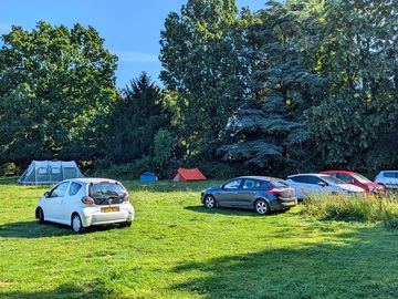 Cars and vans of all types park on the right of the field to leave quiet tent pitches