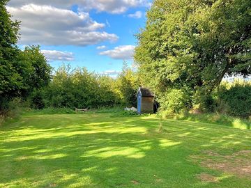 Main pitch area and compost loo with orchard beyond