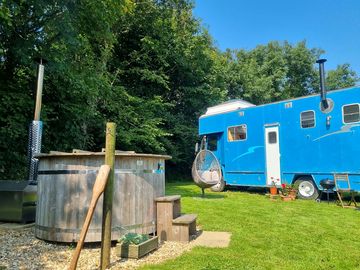 The wood burning hot tub sits next to big blue