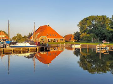 Blik vanaf het water op de boerderij met appartementen.