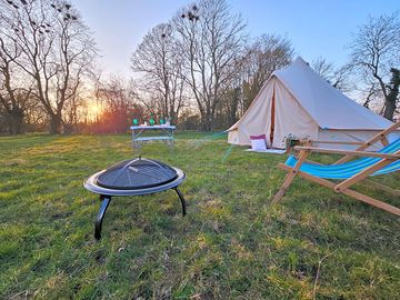 Bell tent with campfire and outdoor seating