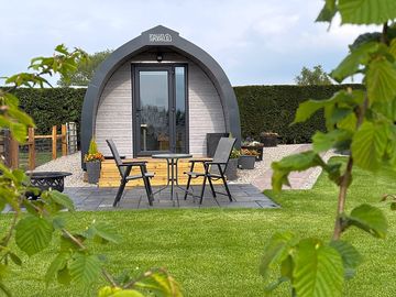View across to honey pod from the field showing patio and path
