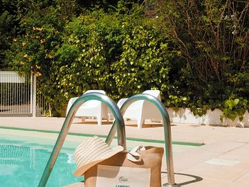Sac de plage et chapeau au bord de la piscine de notre camping val fleuri © léa tavolaro