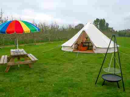 Each bell tent has its own picnic table and cooking firepit