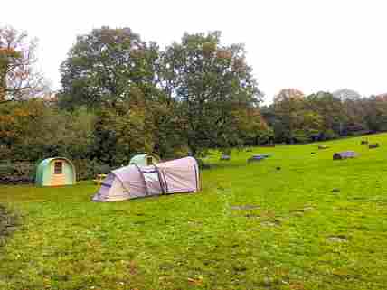 Visitor image of the view across site towards the pods and their tent