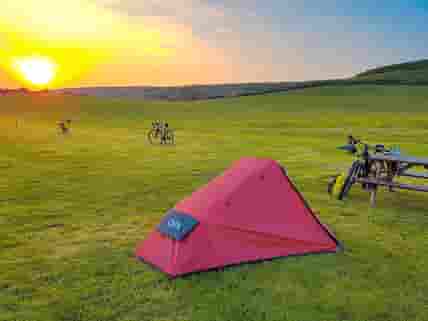 Visitor image of a sunset at the campsite, with lots of bikepackers staying