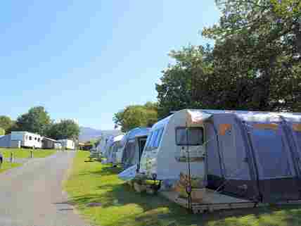 Grass touring pitches backed by trees