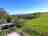 Womerton Farm Campground: View of the pitching field and check-in caravan in the sunshine