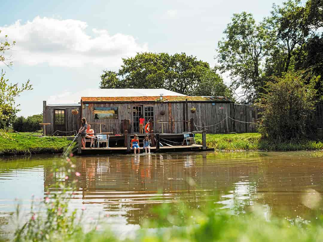 Kings Acre Glamping: Our log cabin and decking next to our small lake