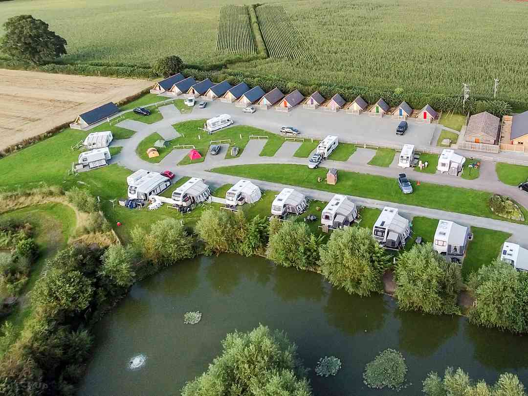 Weston Pools Village: Aerial view of the pitches, the pods and one of the lakes on site