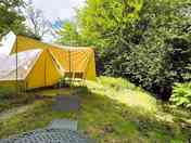 Bell tent exterior, stream and bbq table