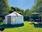 The outside of the yurt and the wooden gazebo for use to cook under if raining
