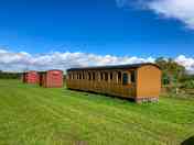 External view of carriage camping pod alongside box wagon camping pods