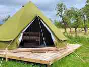 The bell tent with the orchard in the background