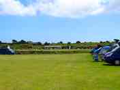 Very flat open field, surrounded by farmers field and local village cricket and football field