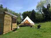 The bell tent kitchen and firepit on a sunny day