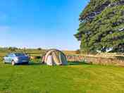Visitor image of the non-electric camp pitch at top of site, with tree for morning shade