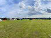 Park along the tree line, do not block any electric hook up points