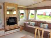 The living area, with L-shaped sofa and electric fire
