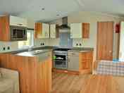 Open-plan kitchen with integrated fridge, freezer and microwave