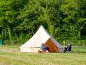 Guests sit outside of the bell tent