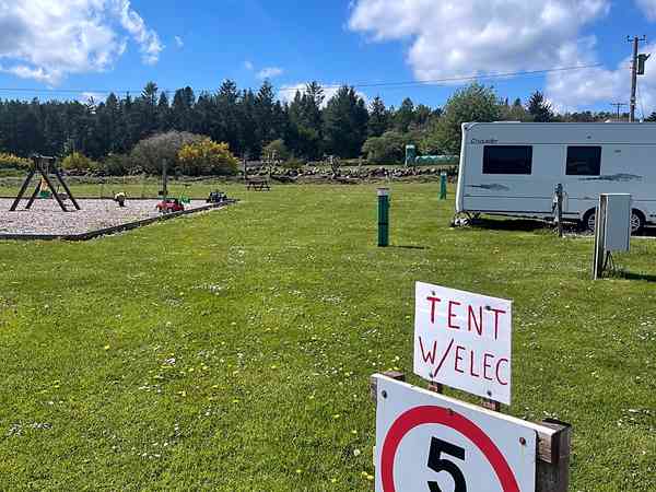 Grasbewachsener Zelt- oder Zeltanhänger-Stellplatz mit Stromanschluss