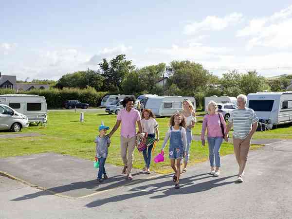 Famliy walking through the touring pitch Famliy walking through the touring pitch