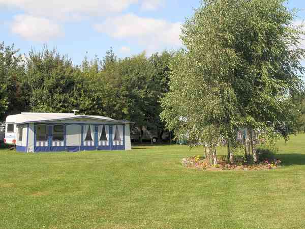 Emplacement pour véhicule de tourisme sur herbe avec électricité (2 adultes et 2 enfants)