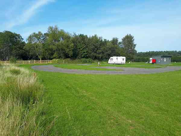 Fully-serviced hardstanding and grass touring pitch (maximum 3 adults)