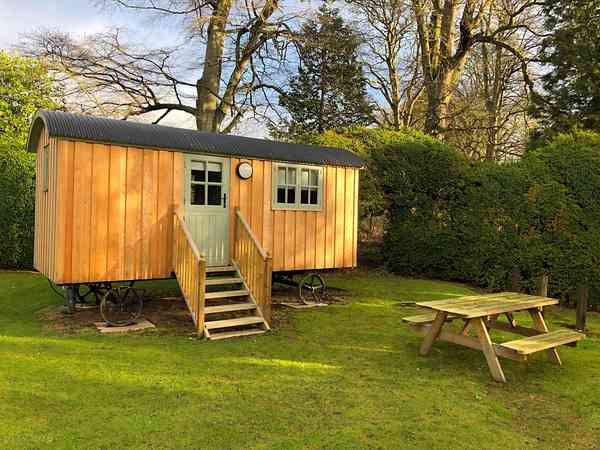Shepherd's hut exterior with picnic table Shepherd's hut exterior with picnic table