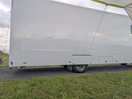 Large trucks parked right next to our campervan and awning.