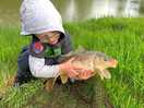 Young boy with a carp from the fishing lake