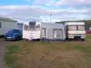 Inconsiderate visitor builds awning right against adjacent hard-standing pitch against site rules.
