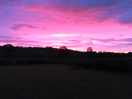 Sunrise over fields and hills.