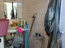 Disabled bathroom full of cleaning equipment, shower completely buried. no attempt to clear it