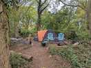 Campsite separated by some brush and trees