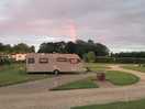Late evening camp photo capturing partial rainbow in the sunset.
